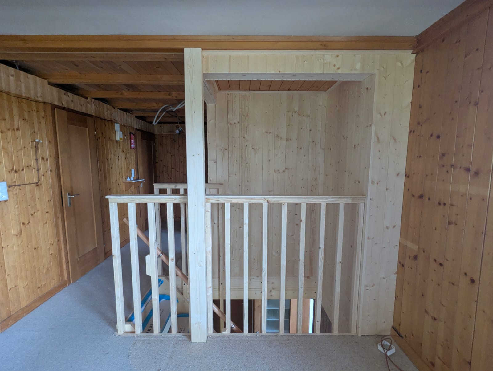 Nieuw trapgat met houten balustrade op de bovenverdieping