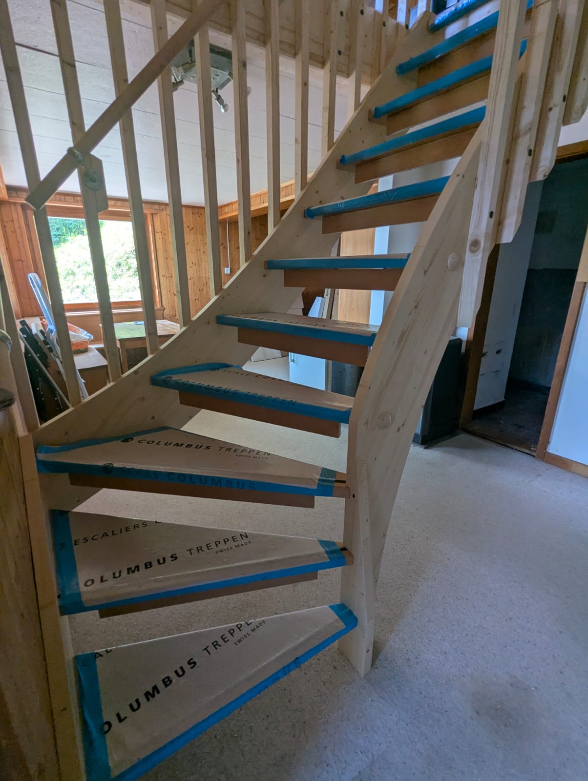 Nieuwe massief houten trap in het chalet, treden nog beschermd met folie